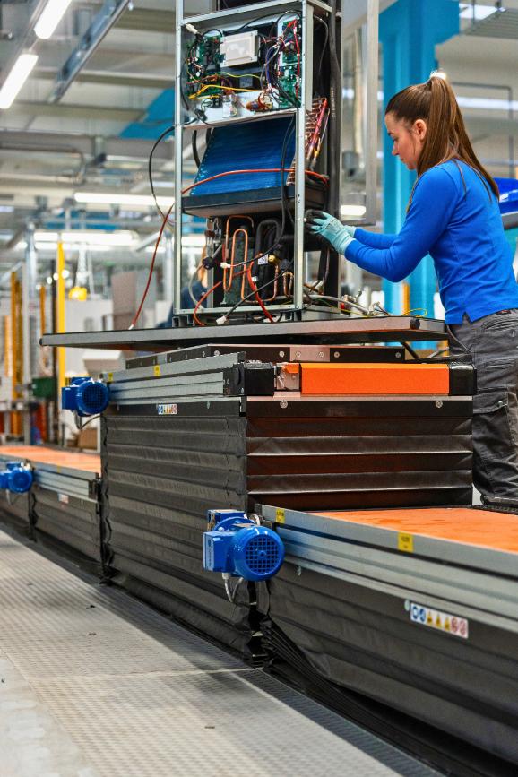Line operator while working on a assembly station with a drilling rig (Scissor lifting table) integrated into the production line made by Movin for the production of HVAC products